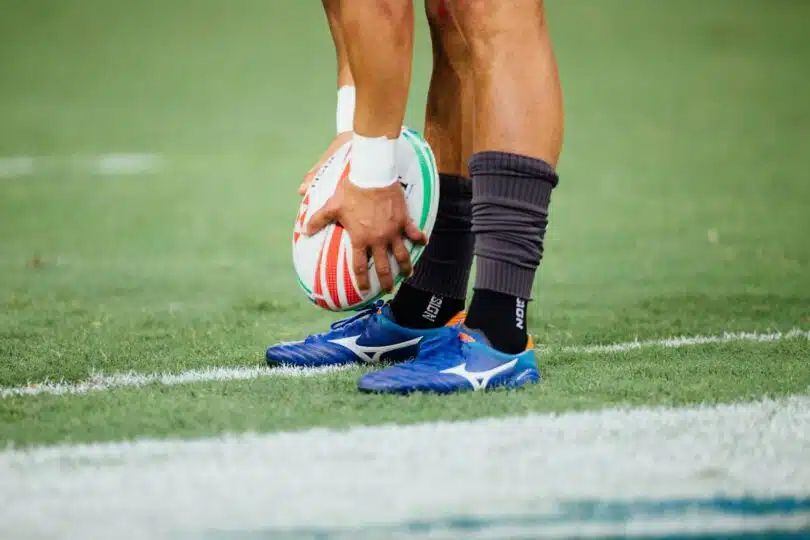 un homme portant un ballon de rugby